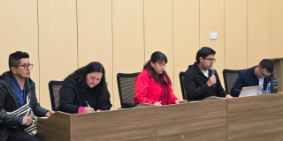 Foto de cuatro personas en un auditorio