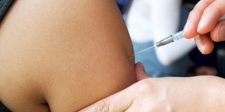 Foto que muestra una persona colocando una vacuna en un brazo 