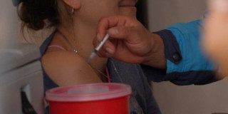 Foto que muestra una enfermera colocando una vacuna en un brazo