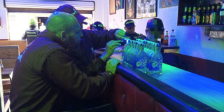 Policía revisando licor adulterado 