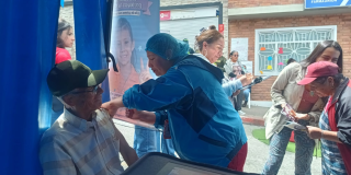 Foto de una enfermera colocando una vacuna en el hombro de una persona