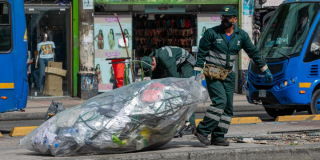 Imagen de Jorge cargando una bolsa de basura en una calle