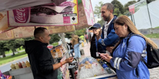 Foto de un vendedor informal junto a gestores sociales del IPES en una calle de Bogotá.