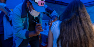 Foto de una enfermera colocando una vacuna en el hombro de una persona