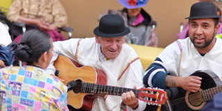 Imagen de una persona mayor tocando guitarra