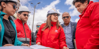 Foto que muestra un grupo de personas hablando con chaquetas rojas y casco blanco