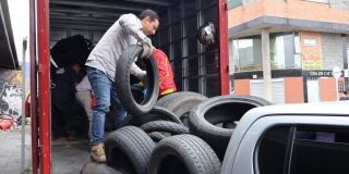 Imagen de una persona cargando llantas