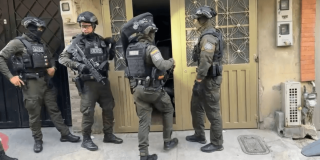 Cuatro uniformados del Grupo de Operaciones Especiales (GOES) entrando a una edificación, durante un allanamiento.