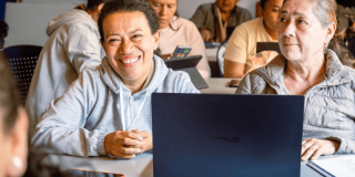 Dos mujeres frente a un computador portátil.