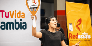 Mujer con una pancarta dando información sobre la trata de mujeres, desde la Red Activa.
