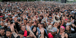 Multitud asiste a concierto masivo al aire libre en Bogotá con miles de asistentes reunidos frente al escenario principal.