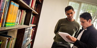 Foto de hombres viendo un libro