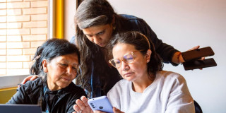 Tres mujeres mirando un celular.