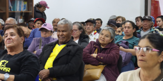 Foto de un grupo de adultos mayores en un auditorio 