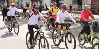 Ciclistas recorren la Ciclovía de Bogotá por una avenida del centro de la ciudad durante jornada recreativa.