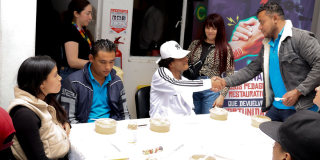 Imagen de varias personas hablando mientras comen