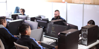 Foto que muestra personas trabajando frente a computadores