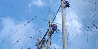 Foto que muestra dos personas con el uniforme de Enel Colombia trabajando en una antena de energía