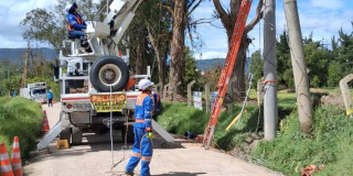 Foto que muestra dos personas con el uniforme de Enel Colombia realizando labores de mantenimiento