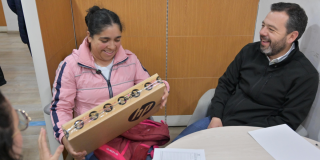 Imagen del alcalde Galán sonriendo junto a una señora quien recibió un computador