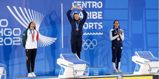 Deportistas reciben medallas durante ceremonia de premiación de los Juegos Centroamericanos y del Caribe Santo Domingo 2026, sobre el podio frente al panel oficial del evento.