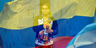 Paradeportista del Equipo Bogotá participa en ceremonia de premiación de los Juegos Parasuramericanos Valledupar 2026, con la bandera de Colombia superpuesta durante la interpretación del himno nacional.