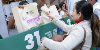 Una mujer recibiendo el kit de la carrera de la media maratón de Bogotá