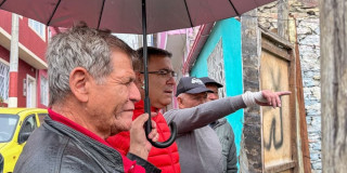 Personas participan en recorrido comunitario con el IDIGER bajo la lluvia durante jornada de diálogo sobre gestión del riesgo en Bogotá.