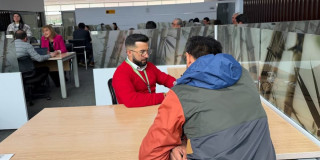 Un funcionario de la DIAN atendiendo a un ciudadano 