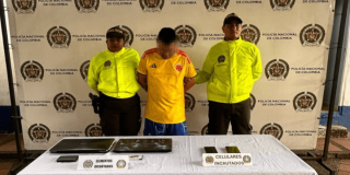 Hombre capturado en medio de dos policías, junto a elementos incautados.