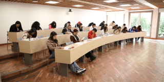 Foto que muestra personas sentadas en un salón