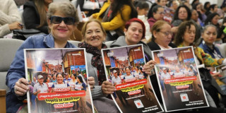 Mujeres emprendedoras mostrando un afiche de la Secretaría de Hacienda