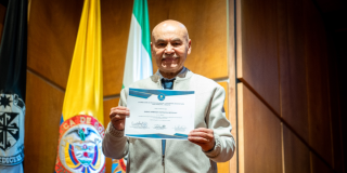 Foto de un adulto mayor con un certificado