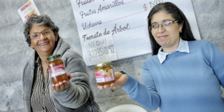Imagen de dos mujeres mostrando unos frascos de mermelada