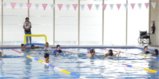 Imagen de varias personas nadando en una piscina