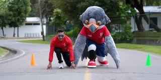 Persona y mascota institucional del IDRD realizan salida deportiva en pista durante actividad recreativa que promueve programas de deporte, actividad física y recreación para todas las edades en Bogotá.