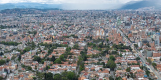 Vista panorámica de Bogotá con amplia zona residencial, edificaciones densas, avenidas principales, cerros orientales y cielo nublado asociada al pronóstico del clima.