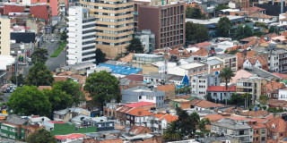 Vista aérea de barrio residencial de Bogotá con edificaciones, zonas verdes y vías urbanas.