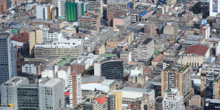 Vista aérea del centro de Bogotá con edificios, oficinas y zonas residenciales en un día soleado y despejado.