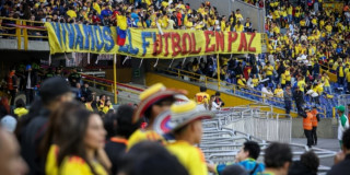 Estadio El Campín con un trapo que dice "Vivamos el fútbol en paz".