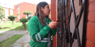 Funcionaria de la Secretaría Distrital de Ambiente realiza visita puerta a puerta en conjunto residencial del barrio Venecia para recopilar información de la comunidad durante jornada de atención ambiental.