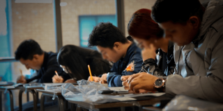 Foto que muestra personas escribiendo en un papel