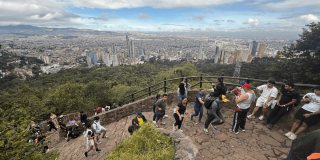 Personas recorren el sendero de Monserrate en Bogotá y descansan en mirador panorámico con vista al centro de la ciudad