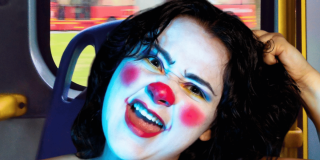 Imagen de una mujer joven que tiene su cara pintada como una payasa.