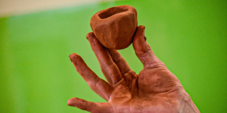 Foto de una mano haciendo una figura con arcilla