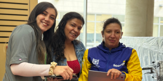 Foto de tres mujeres recibiendo ayudas técnias