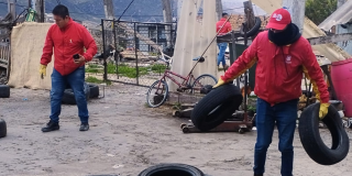 Imagen de dos funcionarios recogiendo llantas en la localidad de Usme
