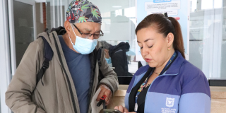 Foto de dos funcionarios de salud en un centro de atención en Bogotá.