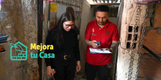 Foto que muestra dos personas una con un metro midiendo y la otra con un cuaderno tomando apuntes