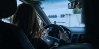 Foto de una mujer conduciendo un vehículo en una vía de Bogotá.